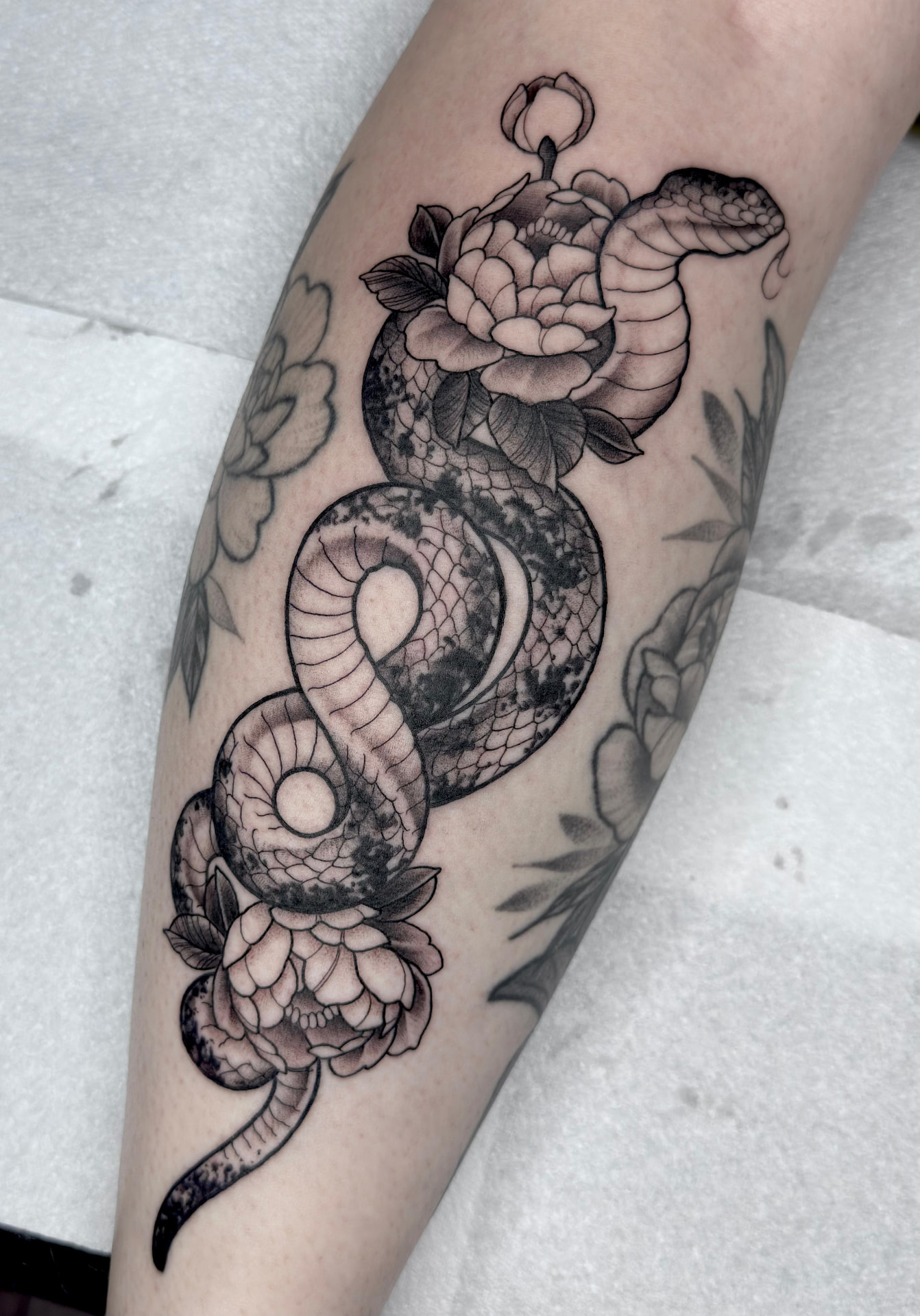 Snake and peonies forearm tattoo by Greg