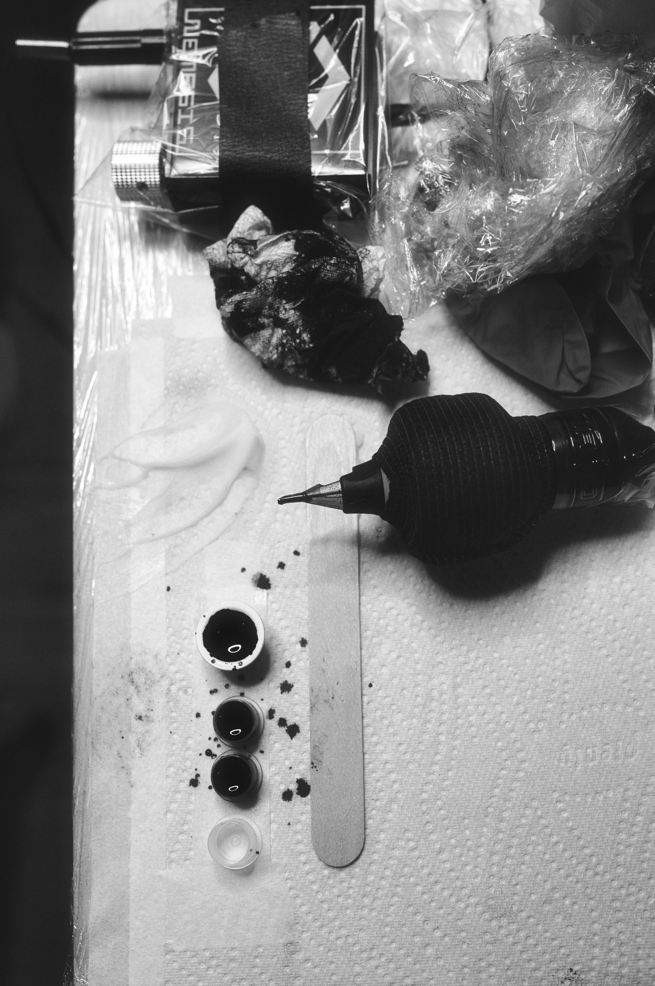 A tattoo machine and ink caps laid out on the workstation at Twin Throne Tattoo Studio